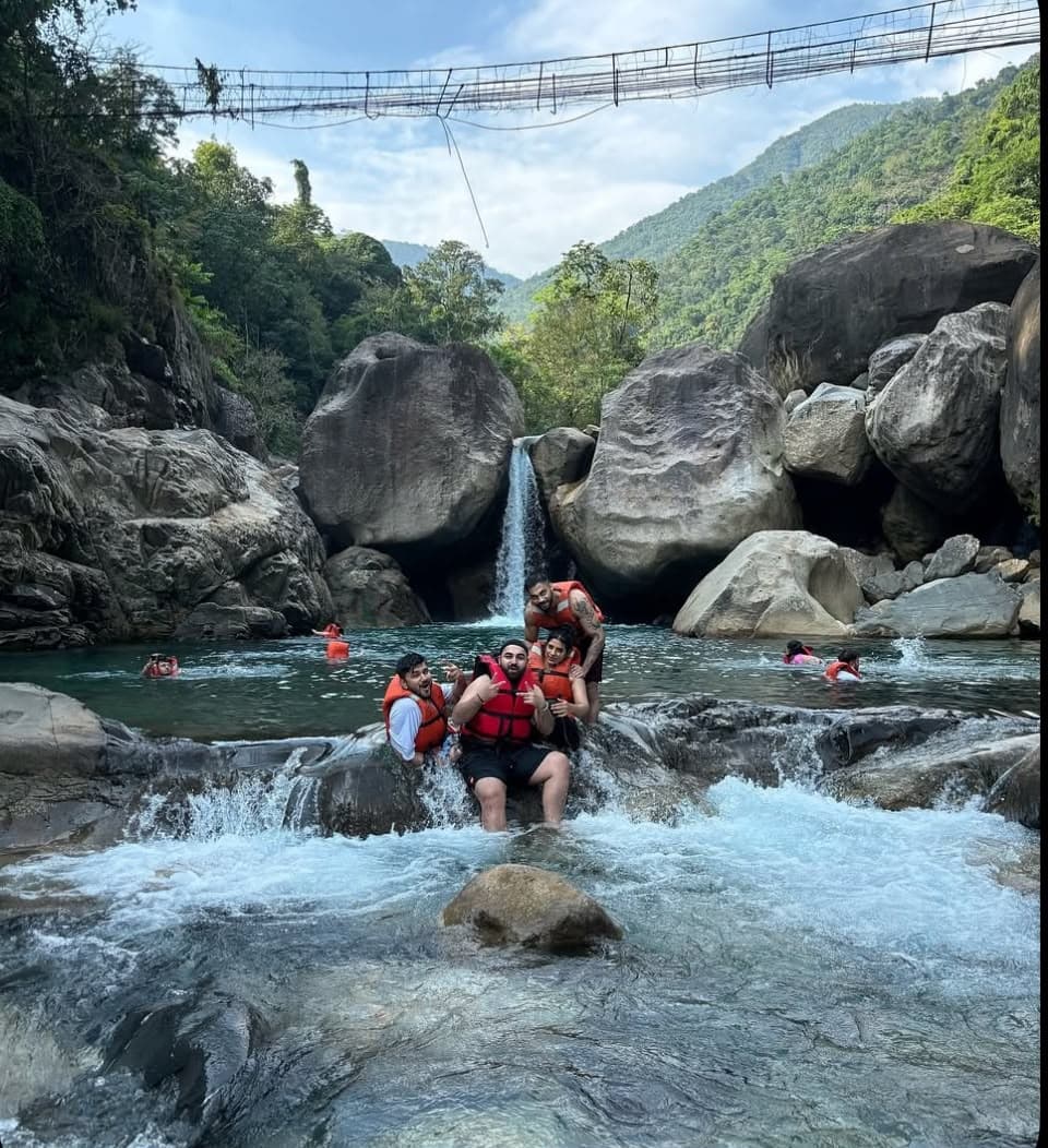 Travelers swimming at a Bali jungle waterfall